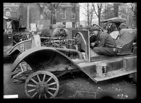 Auto shop work, three men working on car