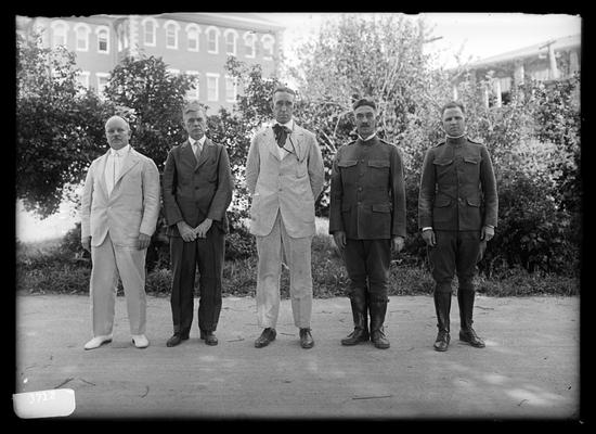 Five men with hats off, two military: Dean F. Paul Anderson, D. Howard Peak, President Frank L. McVey, Commandant H.N. Royden, Captain Harding