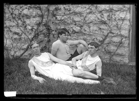 Notation Track athletes, Smith, Whayne and Elliot, April 1898, reclining on ground by side of foundation of building