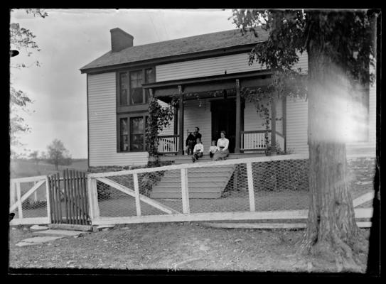 Scott Farm house, woman and two children seated on steps