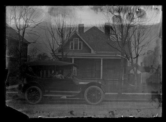 Car in front of house, child