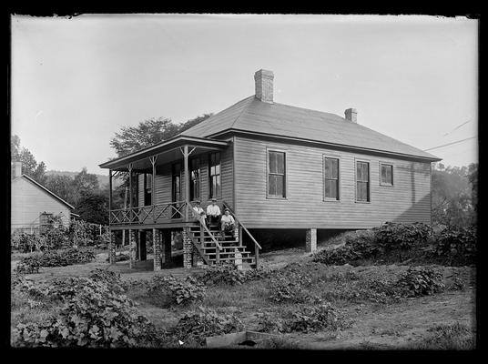 Three men on steps of house