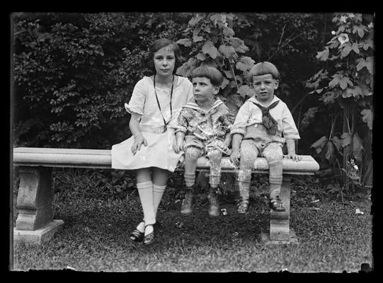 Girl and two boys on stone bench