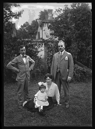 Ella and group, two men, woman and child on ground