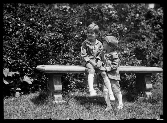 Two boys in middy suits on stone bench