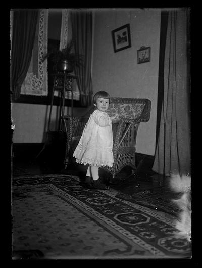 Girl in front of wicker chair