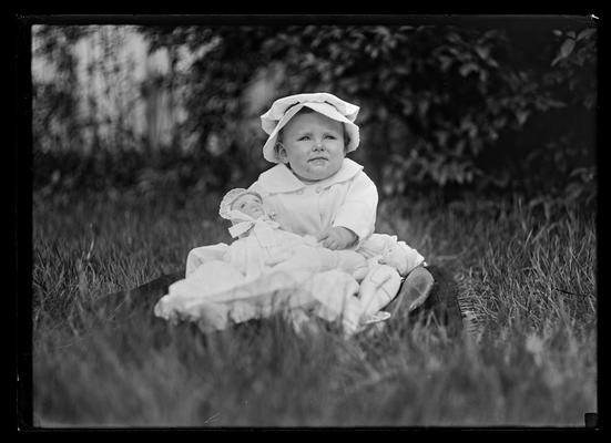 Baby in coat and bonnet with doll, Professor Freeman