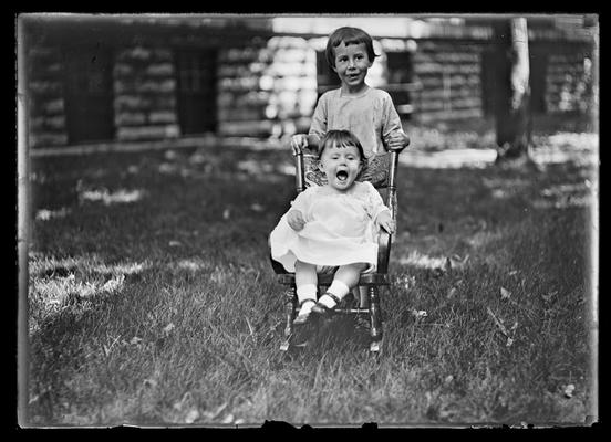 Boy with baby in child's chair