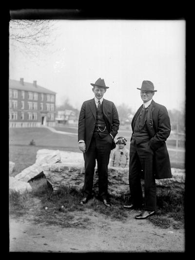 R.C. Stoll and man, child behind rock wall