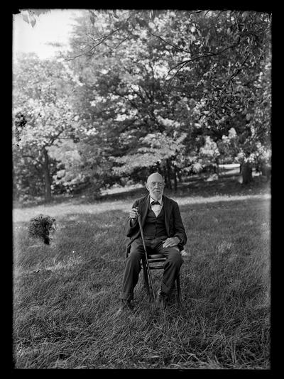 Elderly man with cane seated