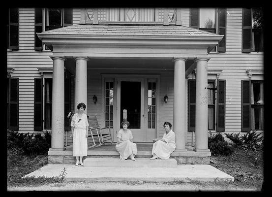 Three young women on steps of porch