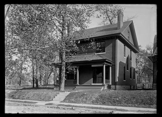 Two story brick house with sloping porch roof