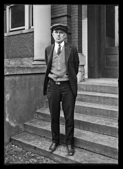 Young man on steps, two keys on watch fob