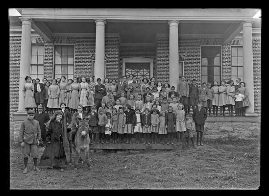 Greendale School (?), students on porch and steps, burro