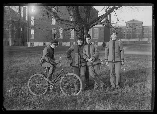 Signal Corps, four members, on UK campus, one of the members is on a bicycle