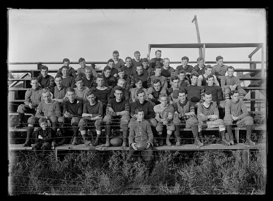 Football squad on bleachers, two young boys