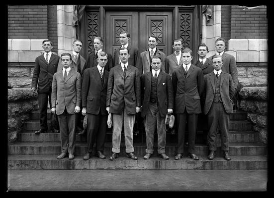 14 men, students on steps of Carnegie Library, two with caps in hand, one with hat, the Student Senate