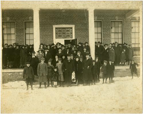 Group portrait of a crowd standing in front of Faulconer school with Governor A.O. Stanley (1867-1958) and Nannie Faulconer (1865?-1940) (Two copies)