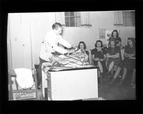 Butcher demonstrating meat cuts to students