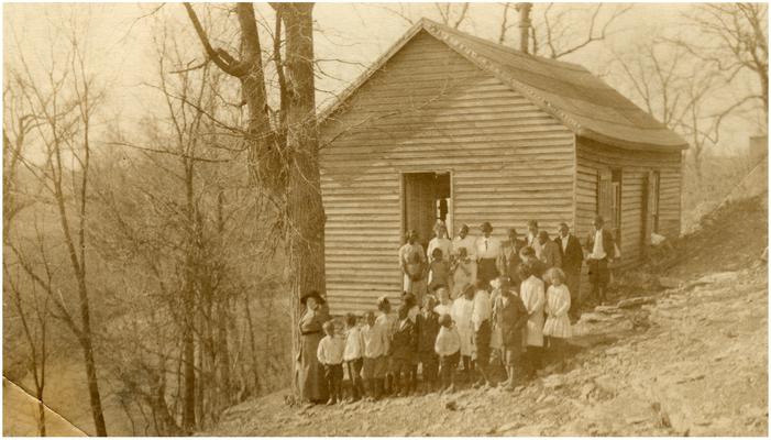 Group portrait of Little Georgetown students and Nannie Faulconer (1865?-1940) standing in front of the school house. Handwriting on verso. (Five copies)