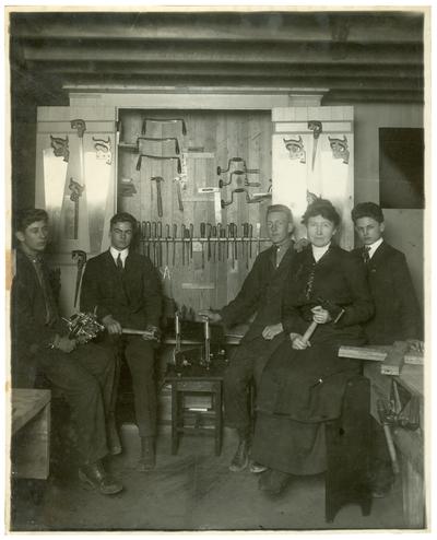 Group portrait of Picadome boys holding tools with Margaret McCubbing. (Two copies)
