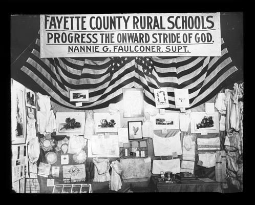 Publicity displays. Banner reads Fayette County Rural School Progress the Onward Stride of God. Nannie G. Faulconer. Supt