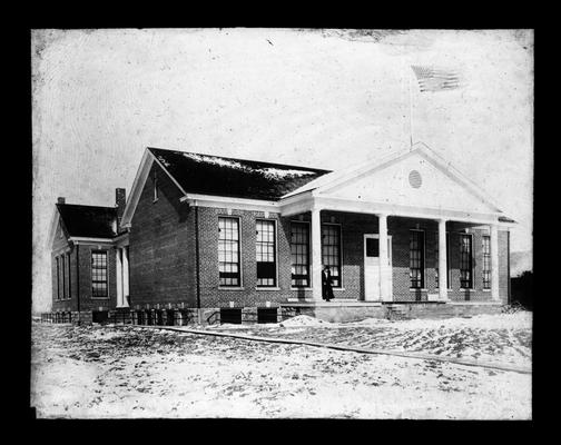Exterior of Faulconer School built in 1916 with Mrs. Nannie Faulconer standing on the front porch (Three copies)