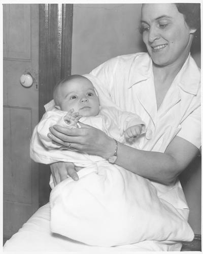 Baby outfitted in garments made in Training Work Center.  (Baby blanket made from cutting scraps