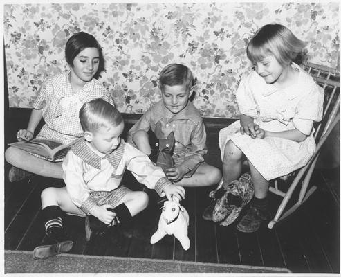 Children wearing garments made in Training Work Center.  Toys made from scraps