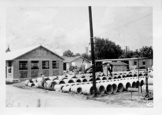 Concrete pipe in back of new Ashland WPA office building, 1940