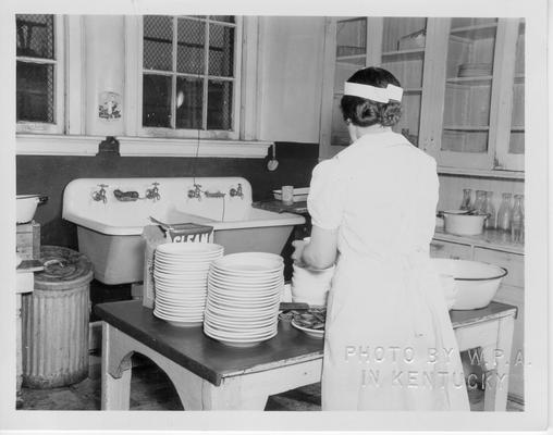 Stacking dishes after a school lunch was served at the Abraham Lincoln School, Lexington, KY, March, 1940