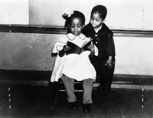 Project #205 District 6: Negro Women's Sewing Center. Two Negro children wearing clothes made on this project and serving as models for the clothing on 