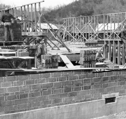 Project #1206 District 2: Construction of an auditorium-gymnasium building, also housing four additional classrooms for the high school at Marrowbone, KY. View shows workmen laying first story walls. Photographed April 4, 1936