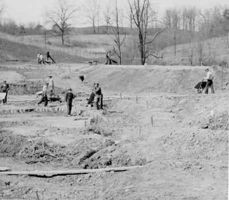 Project #2288 District 5: Construction of eleven fish rearing pools and game hatchery for the State Game and Fish Commission of Kentucky. Site of the project adjoins the Bellefonte Country Club near Ashland, KY. View shows construction of curved earth dam. Photographed March 25, 1936