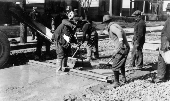 Project #1201 District 6: Utilizing old brick in reconstructed city streets. Spreading cement grout on crushed brick. Photographed February 27, 1936