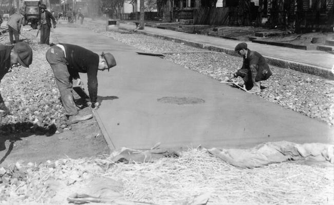 Project #1201 District 6: Utilizing old brick in reconstructed city streets. Spreading the surface concrete. Photographed February 27, 1936