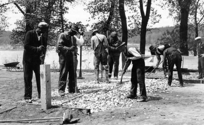 Project #897 District 6: Shawnee Park River Road, Louisville, KY. Construction of a 20-foot, cement bound macadam resurface on the lower River Road in Shawnee Park, Louisville. View shows man completing the northern entrance to Shawnee River Road, shortly prior to pouring the cement grout. Photographed April 28, 1936