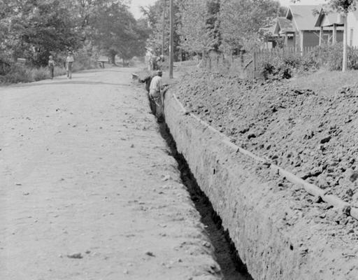 Project #2701 District 1: Installation of 6836 lineal feet of 10-inch cast iron water mains in the City of Madisonville, KY. View, photographed July 24, 1936, shows portion of trench ready for laying pipe