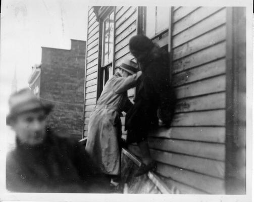 Woman being helped out of a window into skiff in Louisville, KY