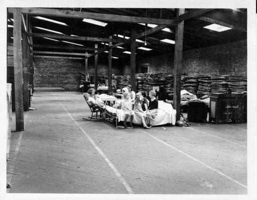 Tobacco warehouse converted to temporary shelter in Louisville, KY. Children are sitting on beds