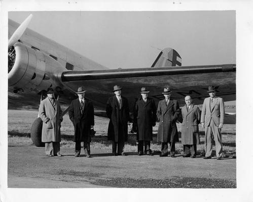 These are the members of the party of Federal Office making a flying inspection trip of airports throughout the country built or improved by the WPA. The photograph was taken just before their departure from the Washington, D.C. airport. Left to right: Gill Robb Wilson, President of the National Association of State Aviation officials; W. Sumpter Smith, aeronautical engineer of the WPA; Corrington Gill, Assistant Administrator of the WPA; Major Lester D. Gardner, Secretary of the Institute of Aeronautical Sciences; Major A.B. McMullen, Chief of the Airport Section of the Bureau of Air Commerce; Fred L. Smith, Executive Vice President of the National Aeronautical Association; and Major Lotha Smith of the War Department. This group stopped in Louisville, KY on November 4, 1937