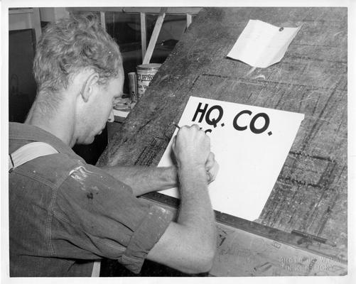 Signs are imperative for purposes of direction in any army camp. WPA workers pain them by the thousands at Ft. Knox. Here we see Howard Ladd, WPA worker, making a headquarters co. sign