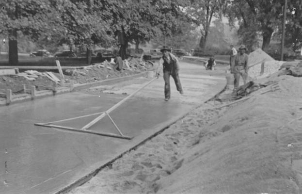 Project #85 District 4: Construction of concrete driveway at Eastern State Teachers' College, Richmond, KY. Floating one-half of finished slab to eliminate waves and irregularities prior to belting
