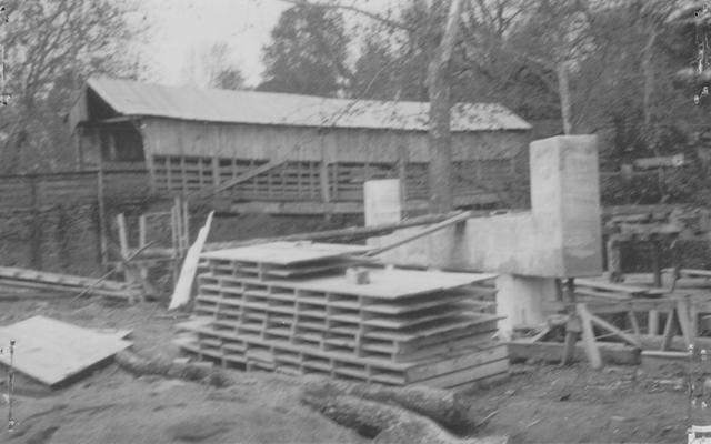 Project #19 District 2: Construction of a reinforced concrete bridge and approaches thereto on Kirkwood Pike. This project replaces an old all-wood covered bridge in a new location. An old landmark that served its purpose well in its day is being replaced by a modern structure. The old servant stands in the background, while one bent of the new structure shows in the foreground
