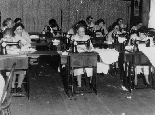 Project #275 District 6: Training Work Center at Shelby and Main streets, Louisville, where women are taught sewing, patching, household management, and child care. Finished articles are turned over to the project's sponsor for distribution to the needy. Two views of the project in operation shown below. Work-rooms, showing sewing machine section. Machines rented by WPA in use