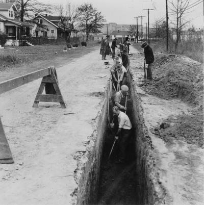 Project #1293 District 6: Construction of sewers in Ward #8, City of Louisville. Excavation for installation of sanitary sewer, Ashland and Livingston Avenues. Men now working at 6' level. Shoring will be used when further depth of trench is excavated. Photographed November 25, 1935