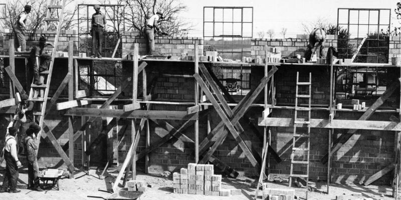 Project #1115 District 2: Construction of an auditorium-gymnasium building for the graded and high school at Mackville, KY. Photograph, taken April 27, 1936, from the interior of building shows workmen laying concrete brick walls