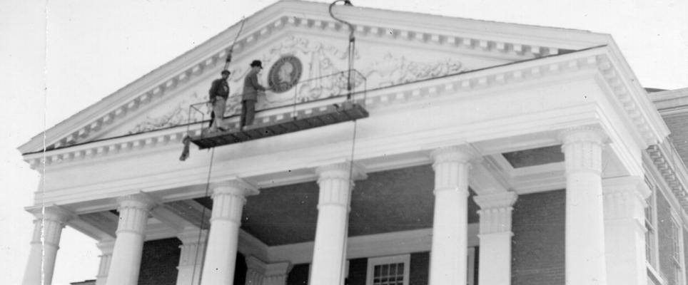 Project #1971 District 6: Federal Art Project at Louisville, KY. General view of entablature and frieze of the Administration Building, University of Louisville, showing an artist painting the University seal on the building. This work was done on the Federal Art Project, #1971, which is being operated at the University, with three relief artists and one non-relief supervisor. View was photographed May 14, 1936