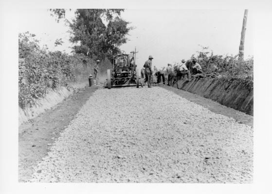 Project #2806 District 2: Master Project #2806 provides for repairing and improving various roads in Garrard County. A total distance of 16.2 miles of county roads is to be graded, drained and surfaced. Workmen laying base stone on the Fork Church Road. View photographed August 31, 1936