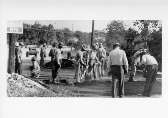 Project #804 District 6: Project #804 is for surfacing various streets in Bowling Green, KY. Workmen placing and spreading native rock asphalt on a street in Bowling Green. View photographed September 25, 1936